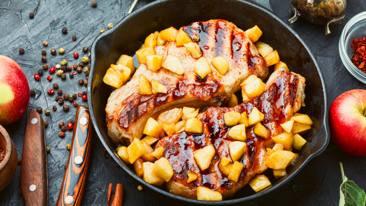 Savor the flavors of autumn with succulent grilled pork chops topped with caramelized apples, perfectly seasoned and paired with vibrant red apples and aromatic spices, creating a warm, inviting dish that celebrates the harvest season.