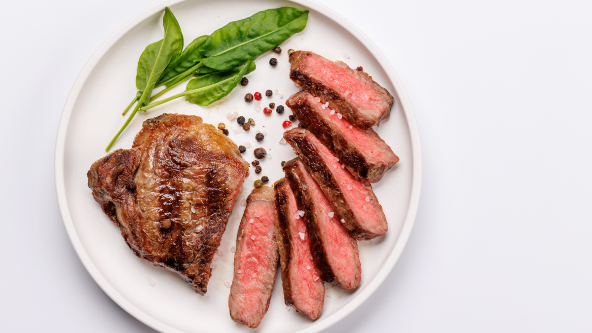 A perfectly cooked sliced striploin medium-rare steak with a juicy, tender texture on a white background
