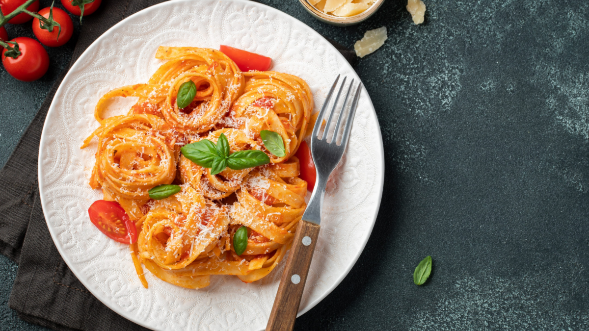 A mouthwatering plate of spaghetti twirls elegantly, draped in a rich tomato sauce and sprinkled with fresh basil. Accompanied by vibrant cherry tomatoes and delectable condiments, this dish embodies a cozy Italian dining experience that invites all to gather around the table.