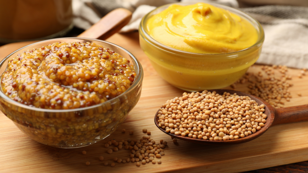 Different types of mustard on wooden table,