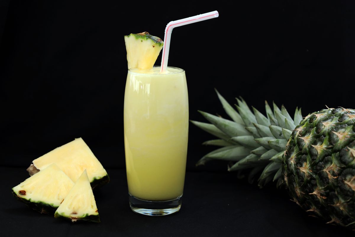 8 Effects Of Eating Pineapples. 1 A tropical glass of fresh pineapple juice garnished with a slice and straw, perfect for summer refreshment.