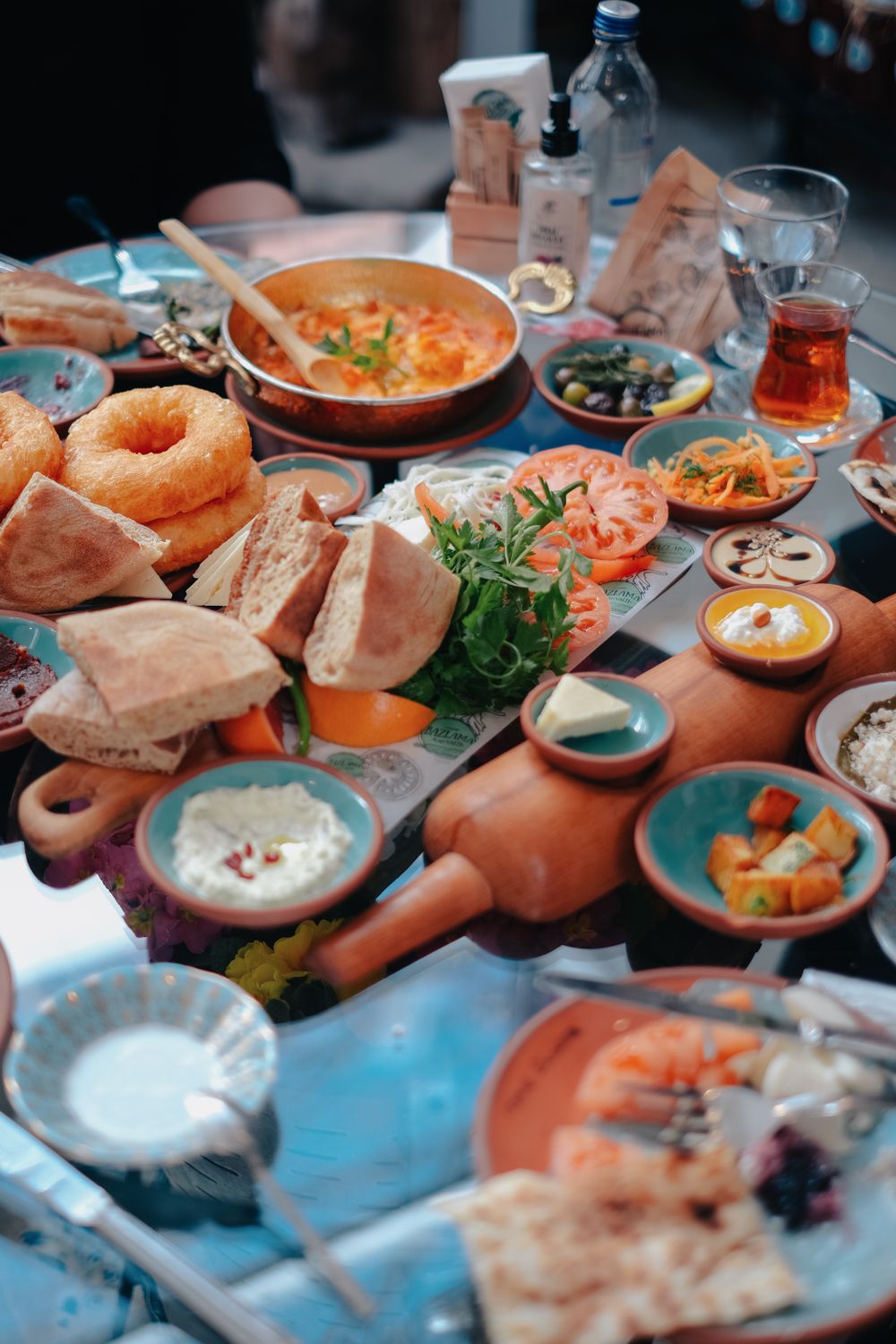 A vibrant spread of Middle Eastern dishes arranged on a dining table, showcasing an assortment of breads, dips, and pickles.