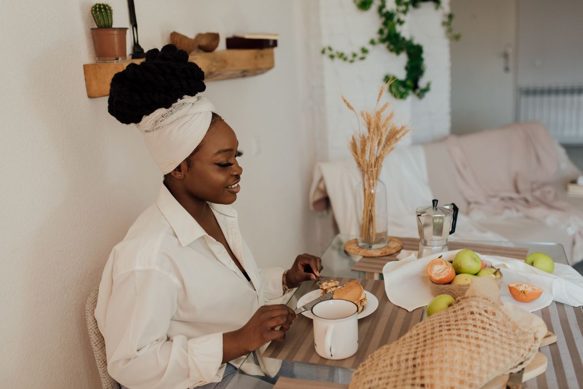 An adult woman enjoying a healthy breakfast in a stylish and cozy home interior.