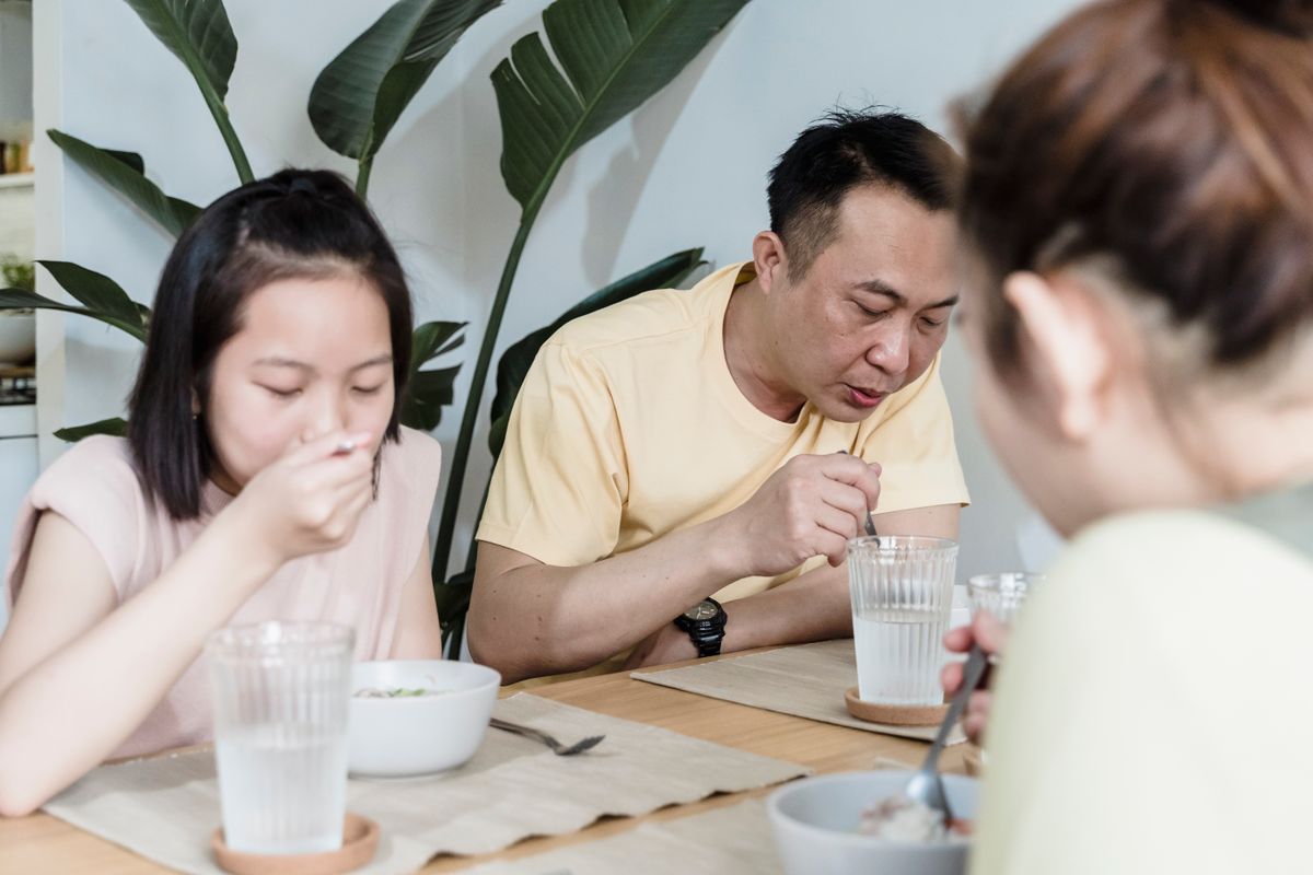 Eating Alone Can Have Negative Effects on Your Health 1 Asian family sharing a meal at home, enjoying quality time together indoors.
