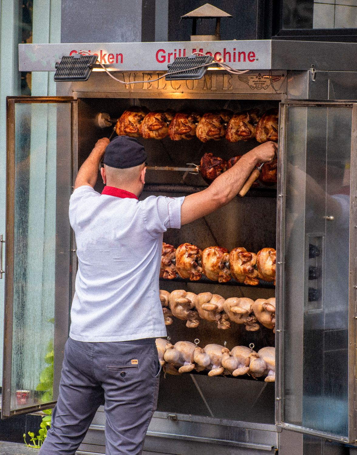 One Rotisserie Chicken, 10 Totally Different Dinners: Your Weeknight Shortcut Just Got Delicious 1 Chef grilling rotisserie chickens on a street using a large grill machine.
