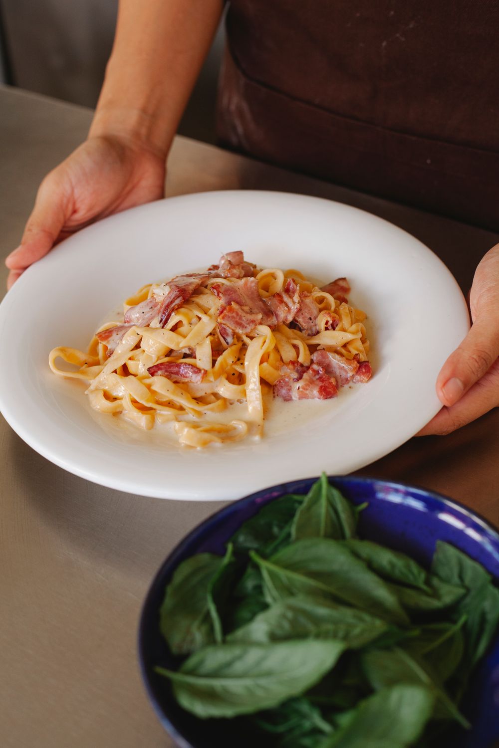 Udon Carbonara Is the Creamy Noodle Mash-Up Everyone Wants to Try 2 Close-up of a fresh tagliatelle carbonara with basil. Perfect for Italian cuisine lovers.