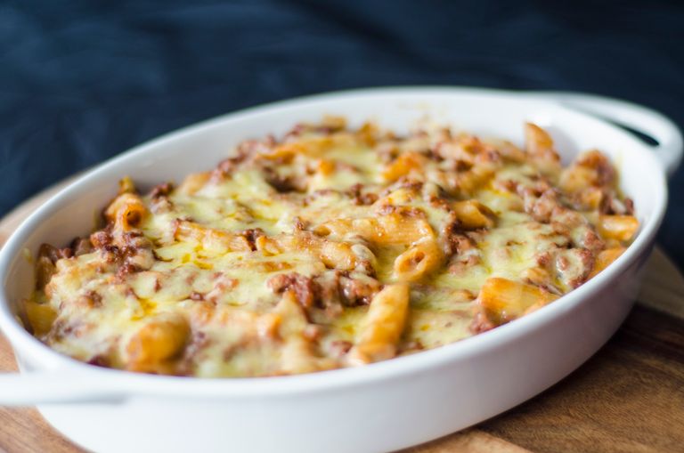 Close-up of a homemade baked macaroni and cheese in a white dish. Perfect comfort food for lunch or dinner.
