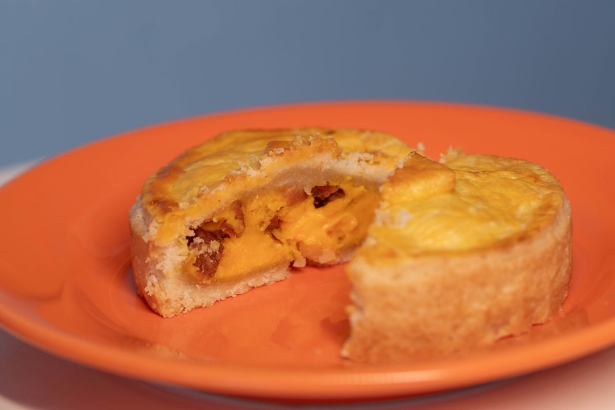 Root Beer in Pie? This Sweet-and-Salty Peanut Dessert Is the Throwback Nobody Saw Coming 2 Close-up of a sliced mango tart on a bright orange plate, showcasing its rich, fruity filling.