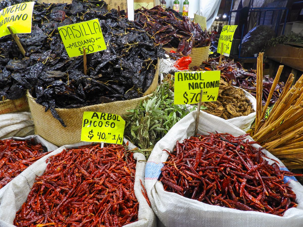 Colorful spices and dried chiles at a bustling market in Mexico City.