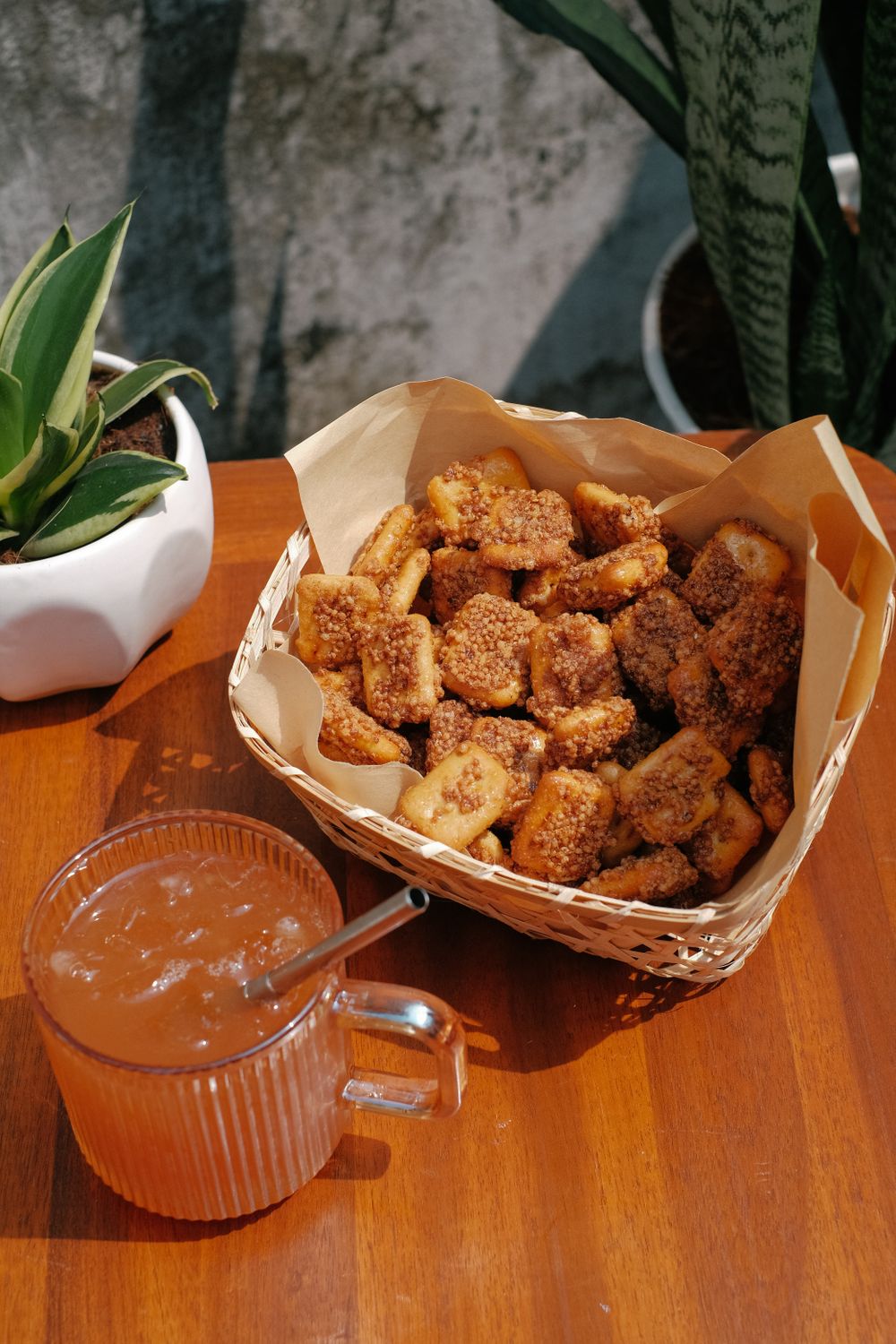 Crispy fried banana snacks served with a refreshing beverage on a sunny day.