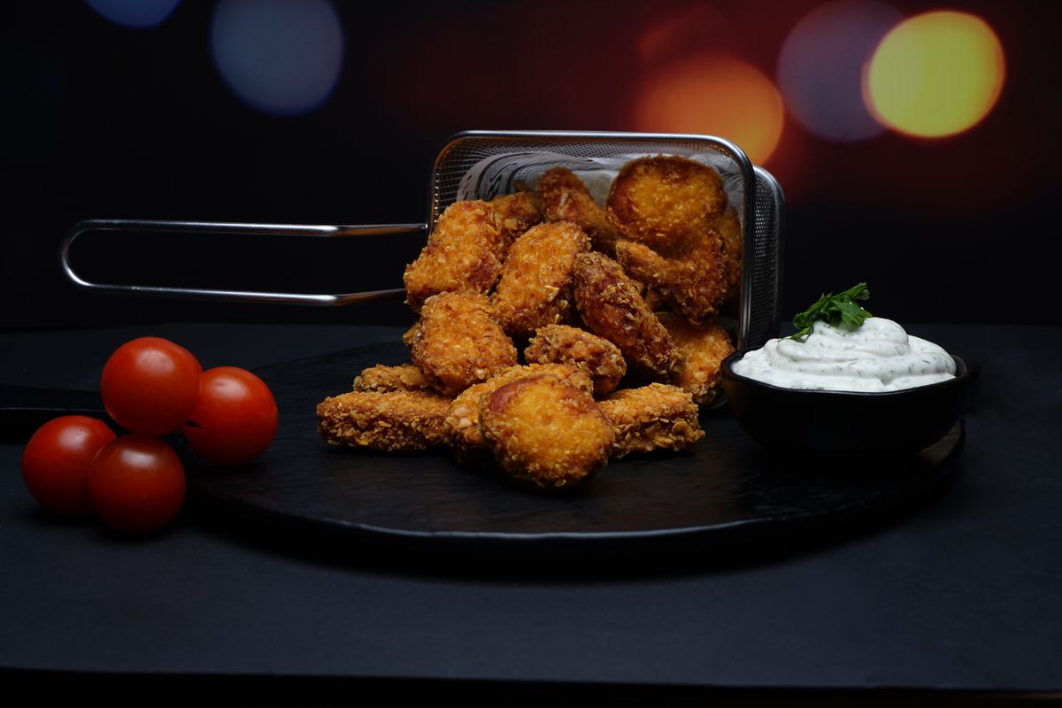 Delicious crispy nuggets served with fresh cherry tomatoes and a side of creamy dipping sauce.