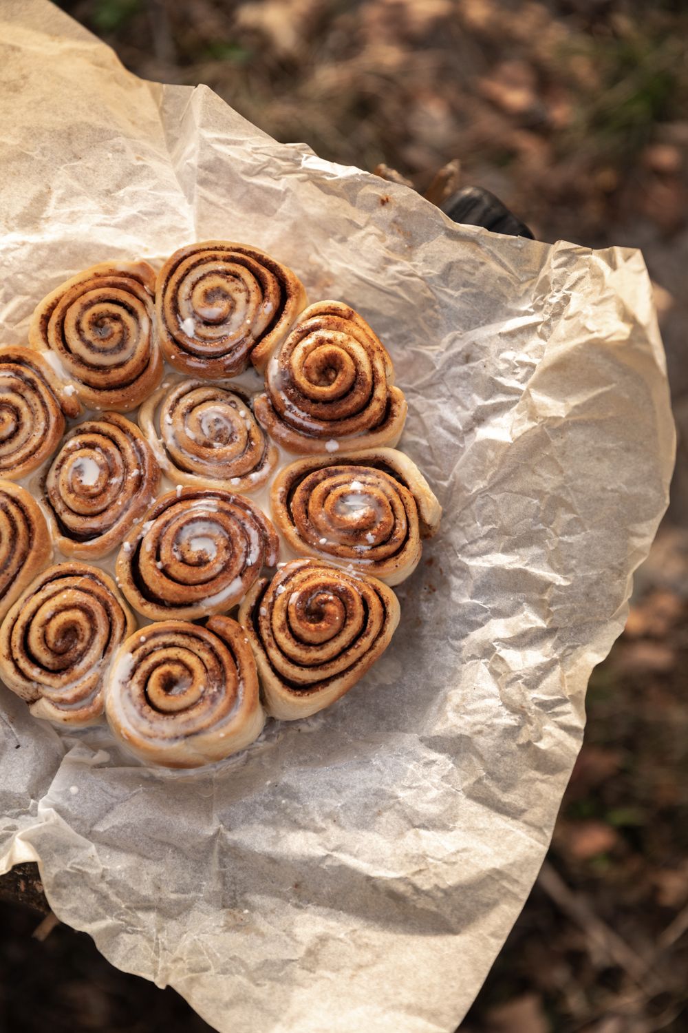 Delicious homemade cinnamon rolls placed on parchment paper, perfect for a cozy breakfast.