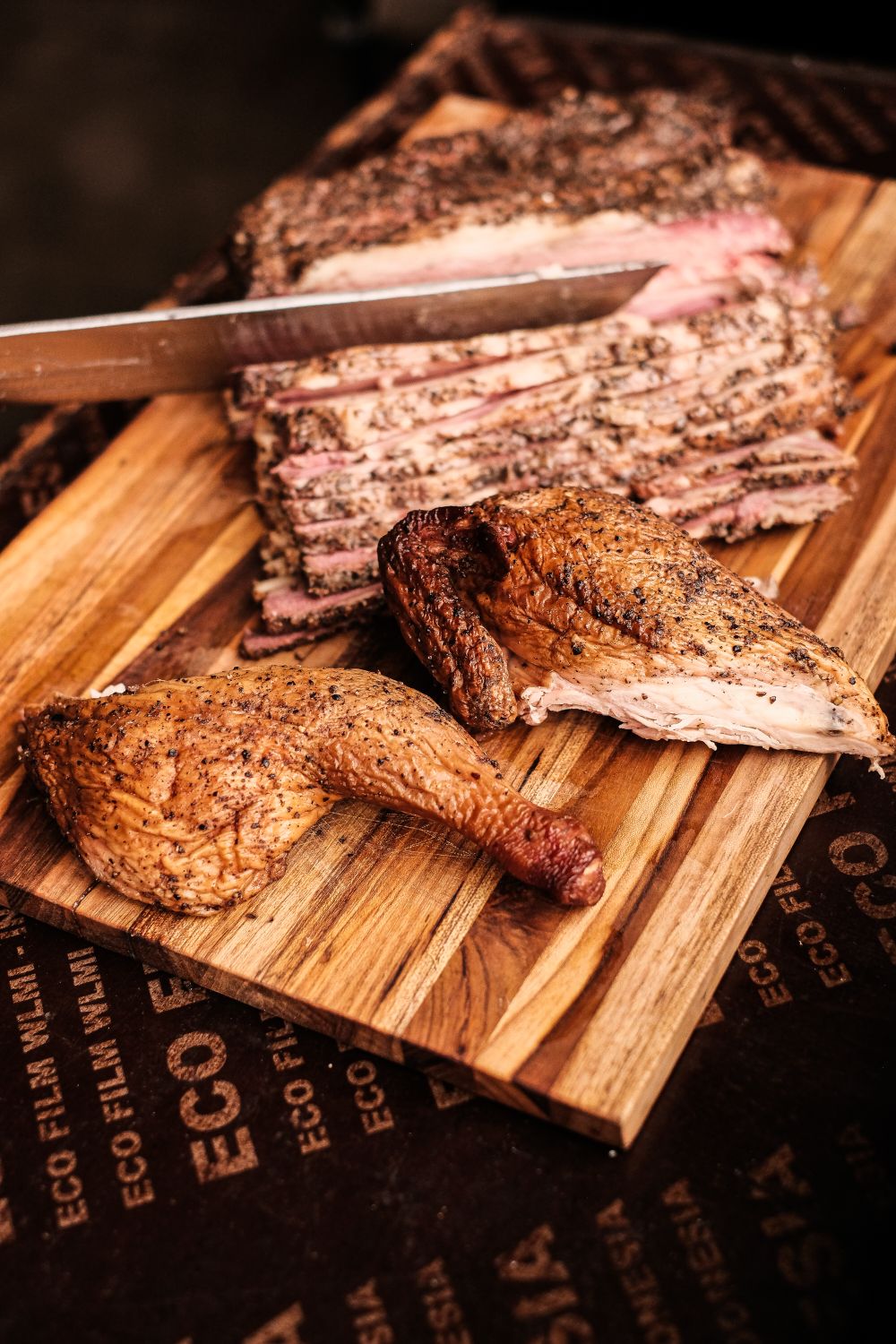 What Happens When Texas Barbecue Meets Thai Food? This New Restaurant Is Finding Out 2 Deliciously smoked barbecue brisket and chicken leg on a wooden board, perfect for a savory feast.
