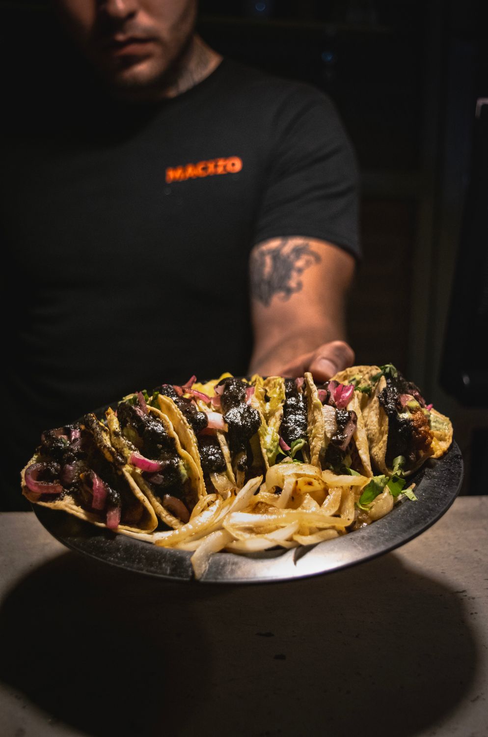 Gourmet beef tacos served with toppings on a plate in a Mexican restaurant.