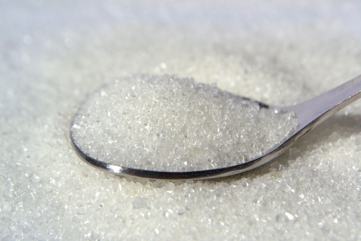 Foods That Refuse to Go Bad: 8 Pantry Staples Built to Last 1 Macro shot of white sugar crystals on a stainless steel spoon, highlighting texture and purity.