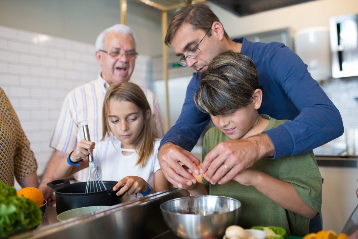 man-in-blue-sweater-assisting-the-boy-in-green-shirt-cracking-eggs-8507611/
