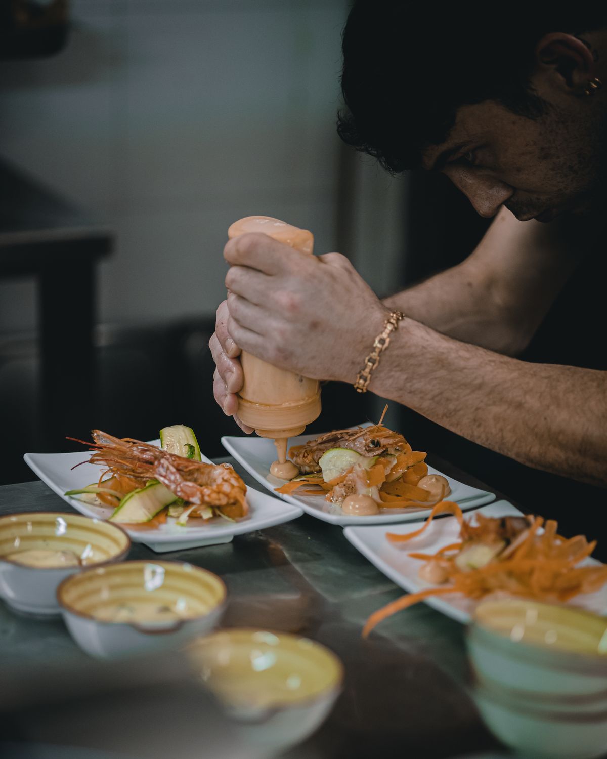 Charcuterie’s New Rival: Why Seafood Boards Are Taking Over High-End Menus 2 Professional chef expertly preparing seafood dish in a restaurant kitchen setting.