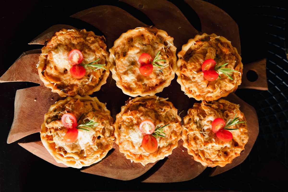 Savor the flavor of freshly baked chicken tartlets topped with cherry tomatoes and rosemary.