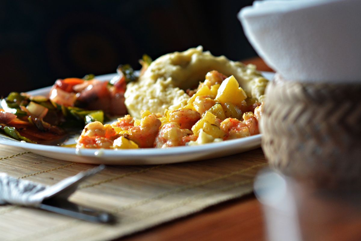 5 Old-Fashioned Dinner Traditions Worth Bringing Back to Your Table 1 Savor this vibrant Ecuadorian seafood dish with potatoes and vegetables served on a wooden table.