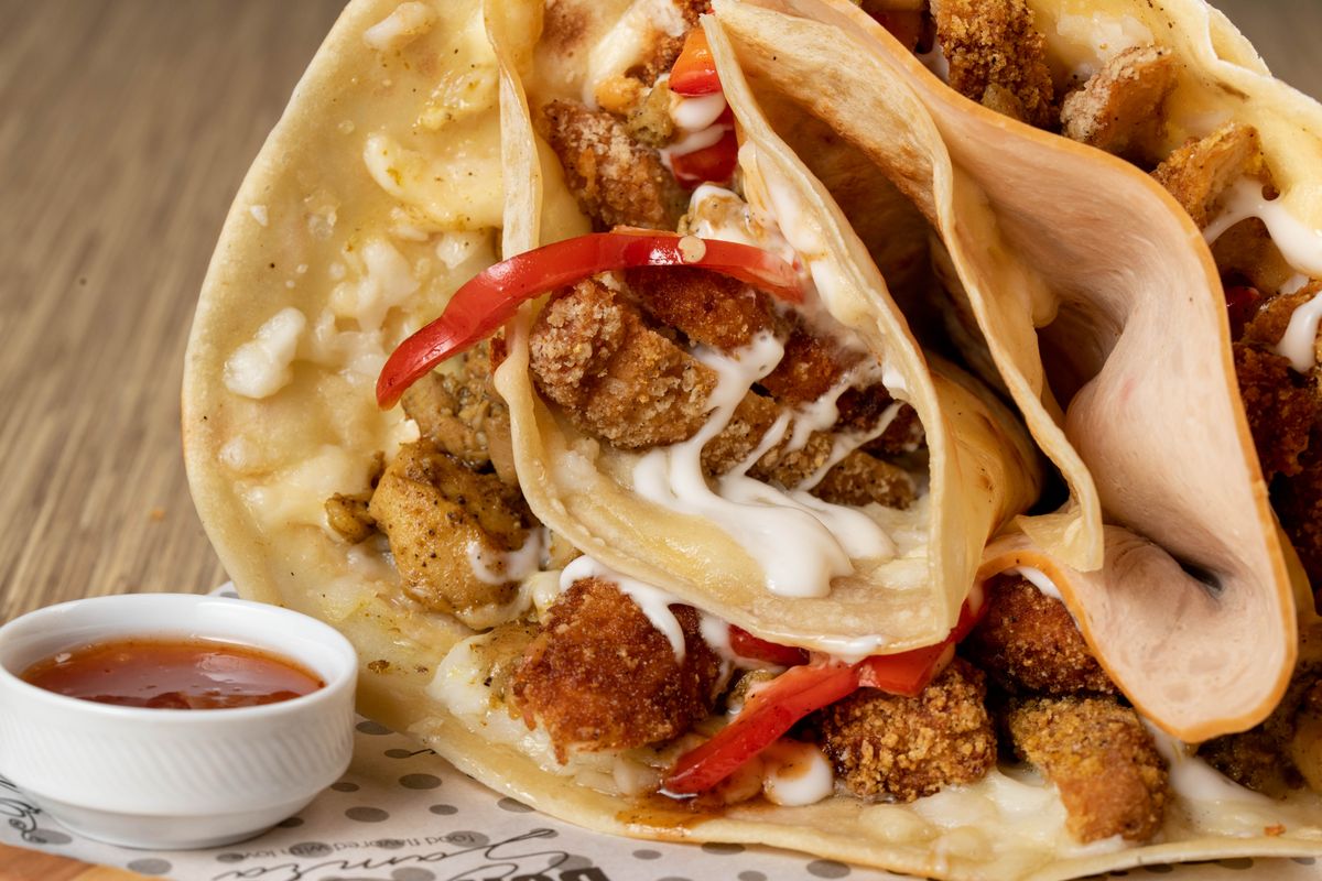 Scrumptious chicken wrap with creamy sauce and peppers, perfect for food enthusiasts.