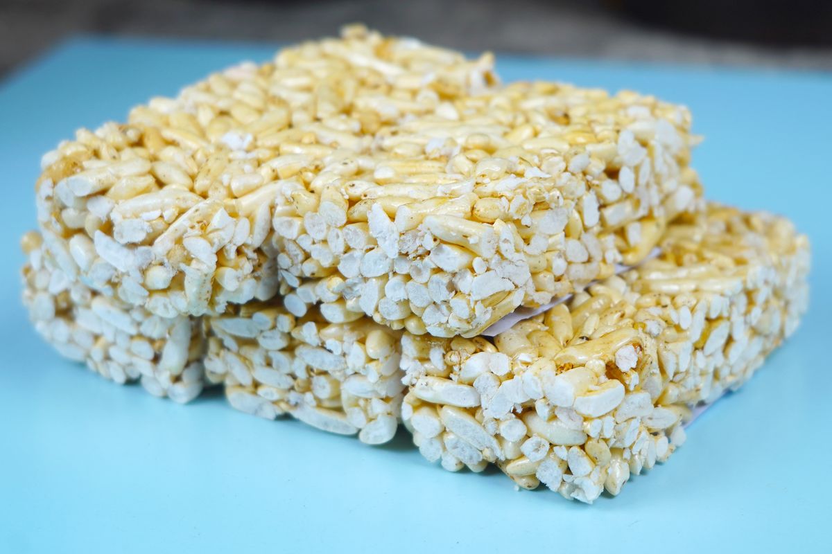 Stacked puffed rice cakes on a blue background, showcasing light texture and healthy snack appeal.