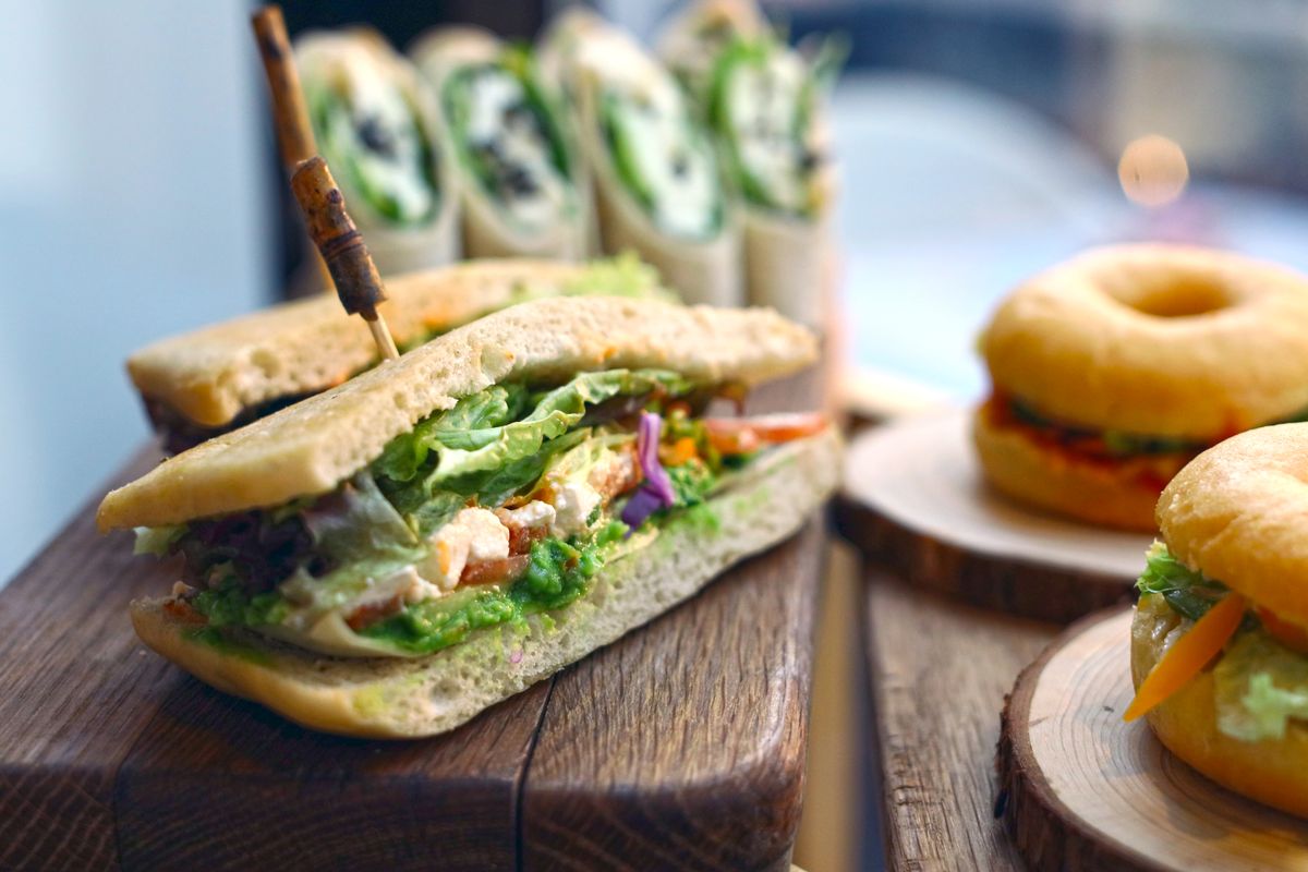 Tasty variety of sandwiches and bagels presented on wooden boards, highlighting gourmet ingredients.