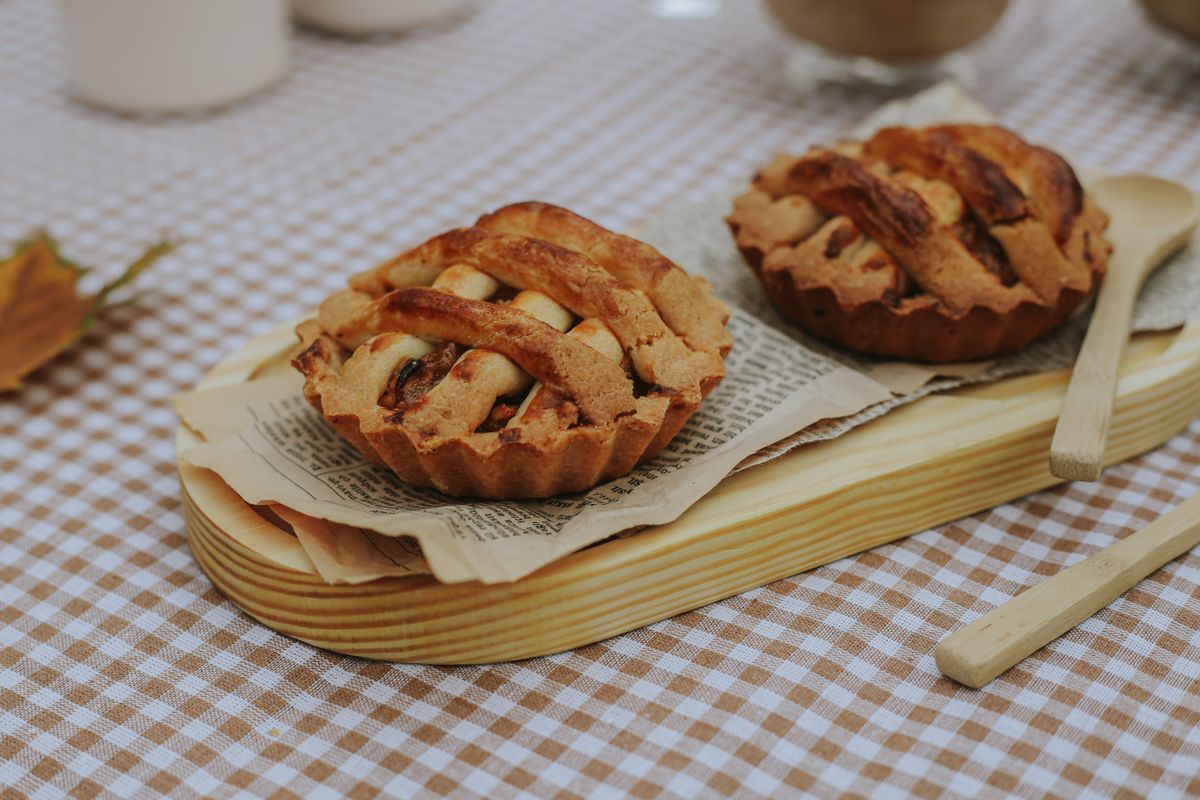 Two rustic mini apple pies served on a wooden board, perfect for autumn picnics.