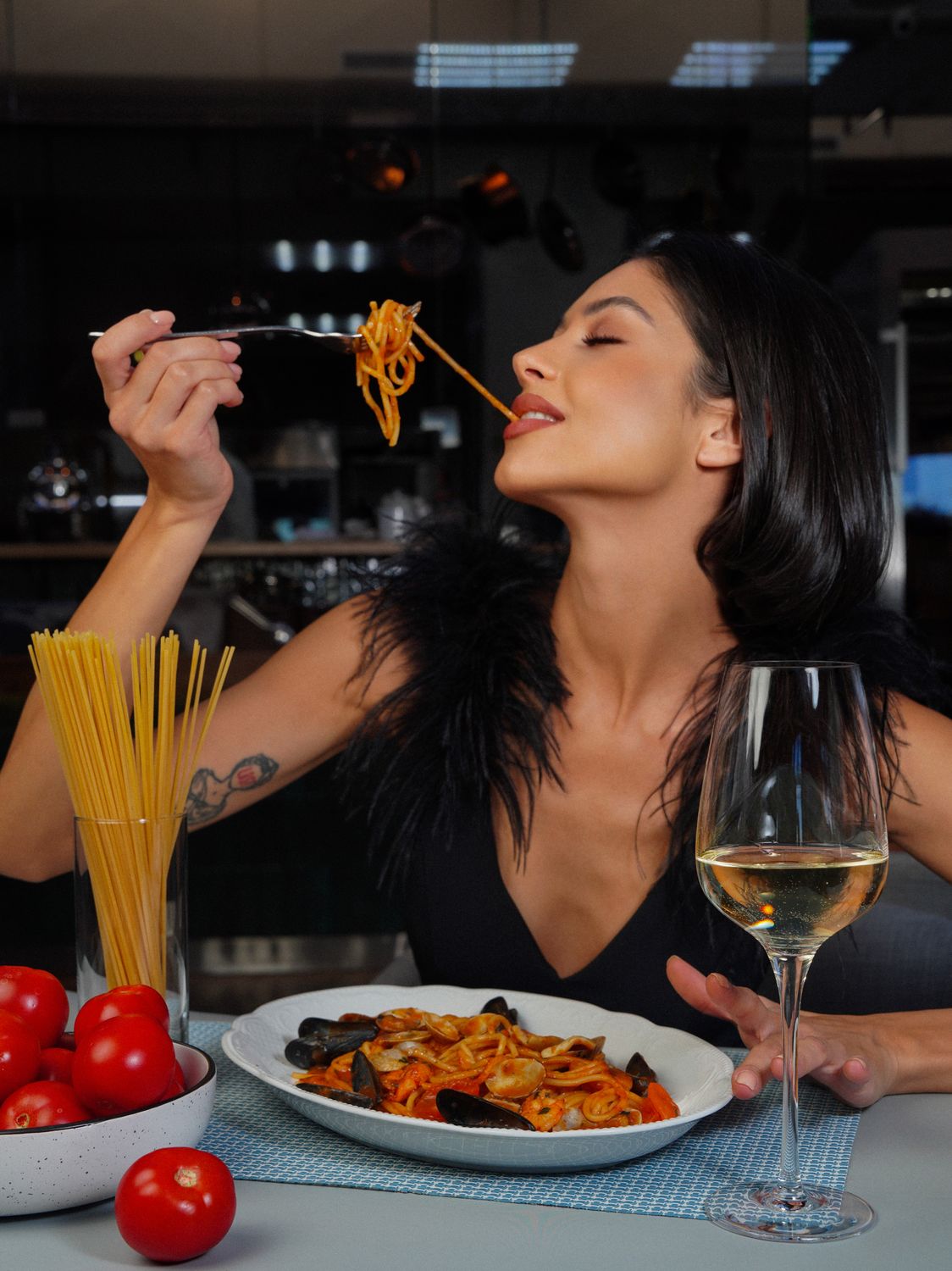 9 Fast Dinners That Taste Like You Spent All Day Making Them 1 Woman enjoying pasta dish paired with white wine in a stylish setting.
