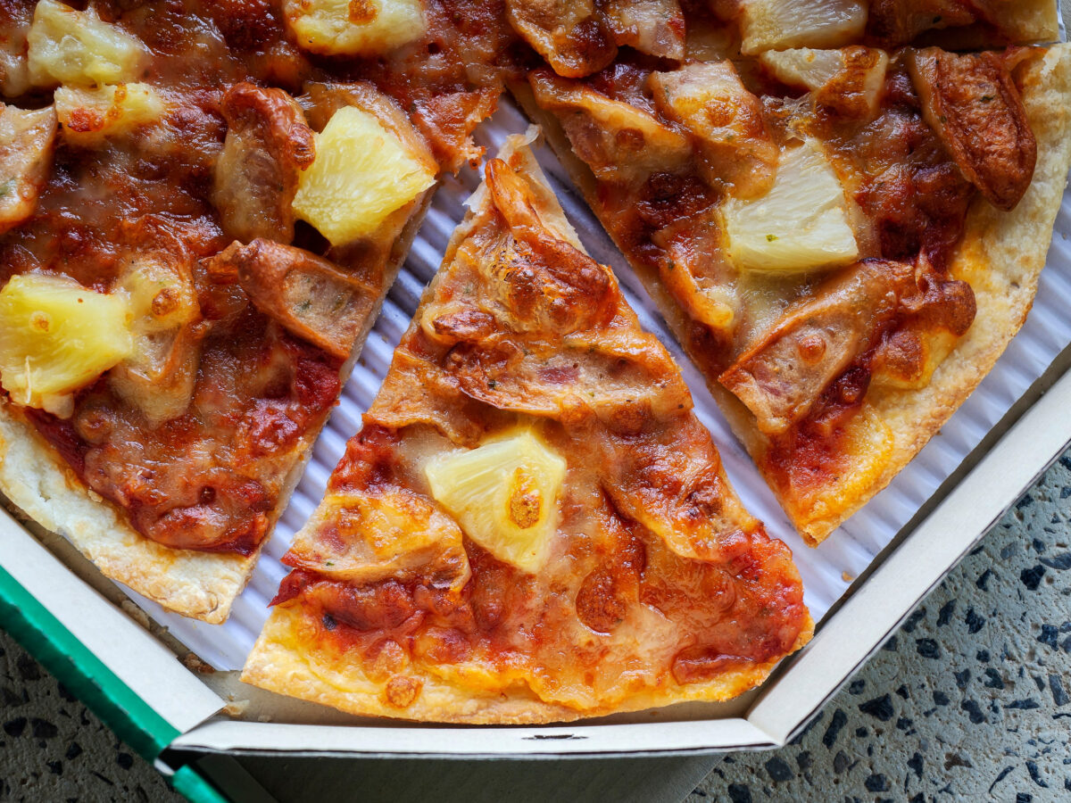 Top view of thin and crispy Pizza in a delivery cardboard box.