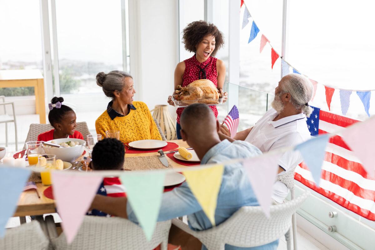 Side view of Multi-generation African American family sitting together for having meal on a dining table at home