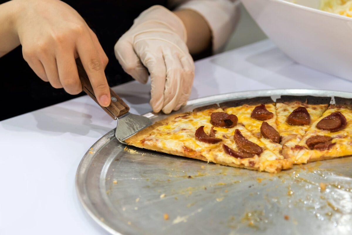 Pizza is delicious , Chef take hot piece of pizza, takes a slice of sliced Pizza