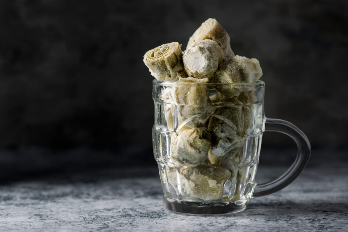 a pile of frozen artichoke hearts in jug glass, on a table or countertop
