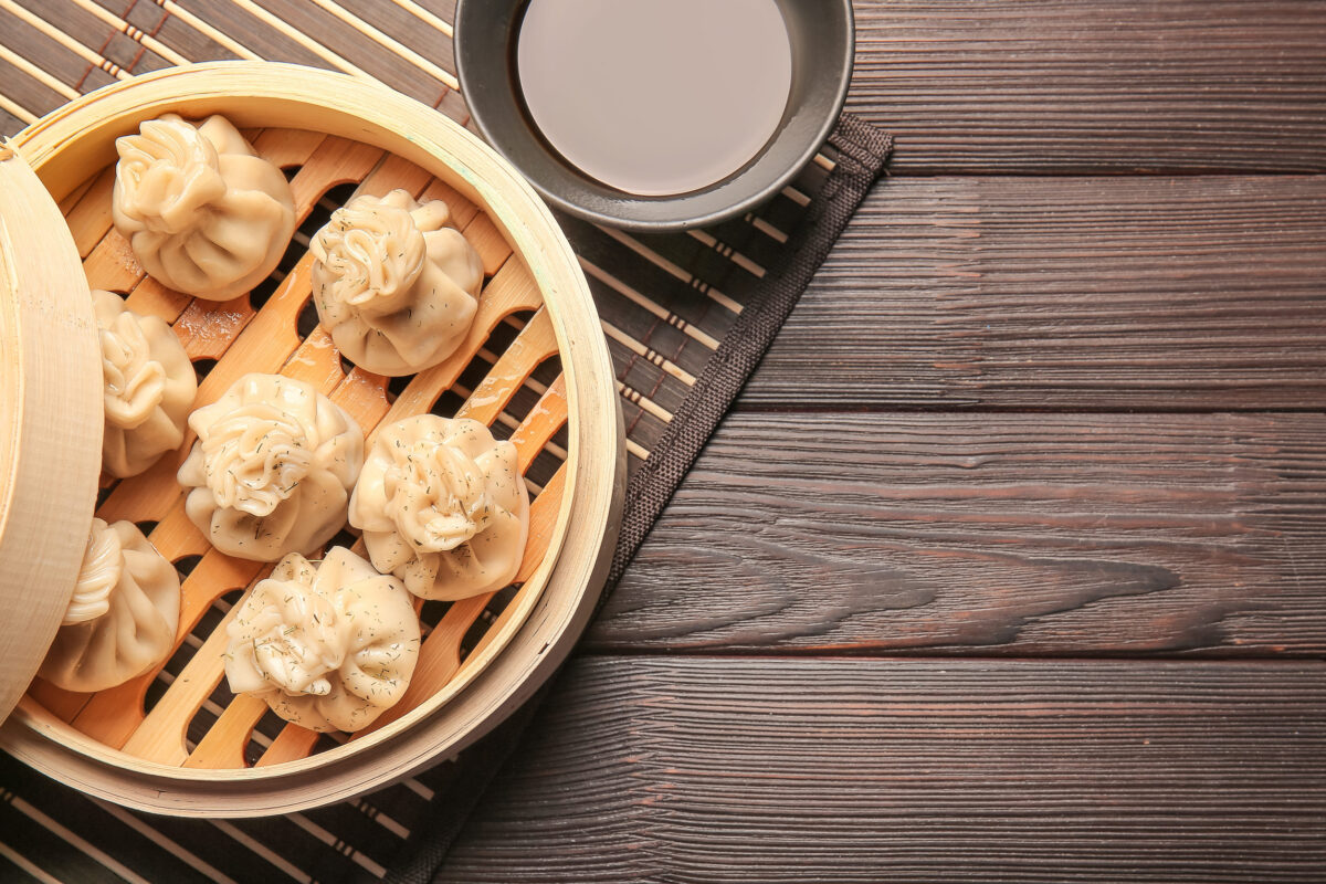 Steamer with tasty dumplings on table