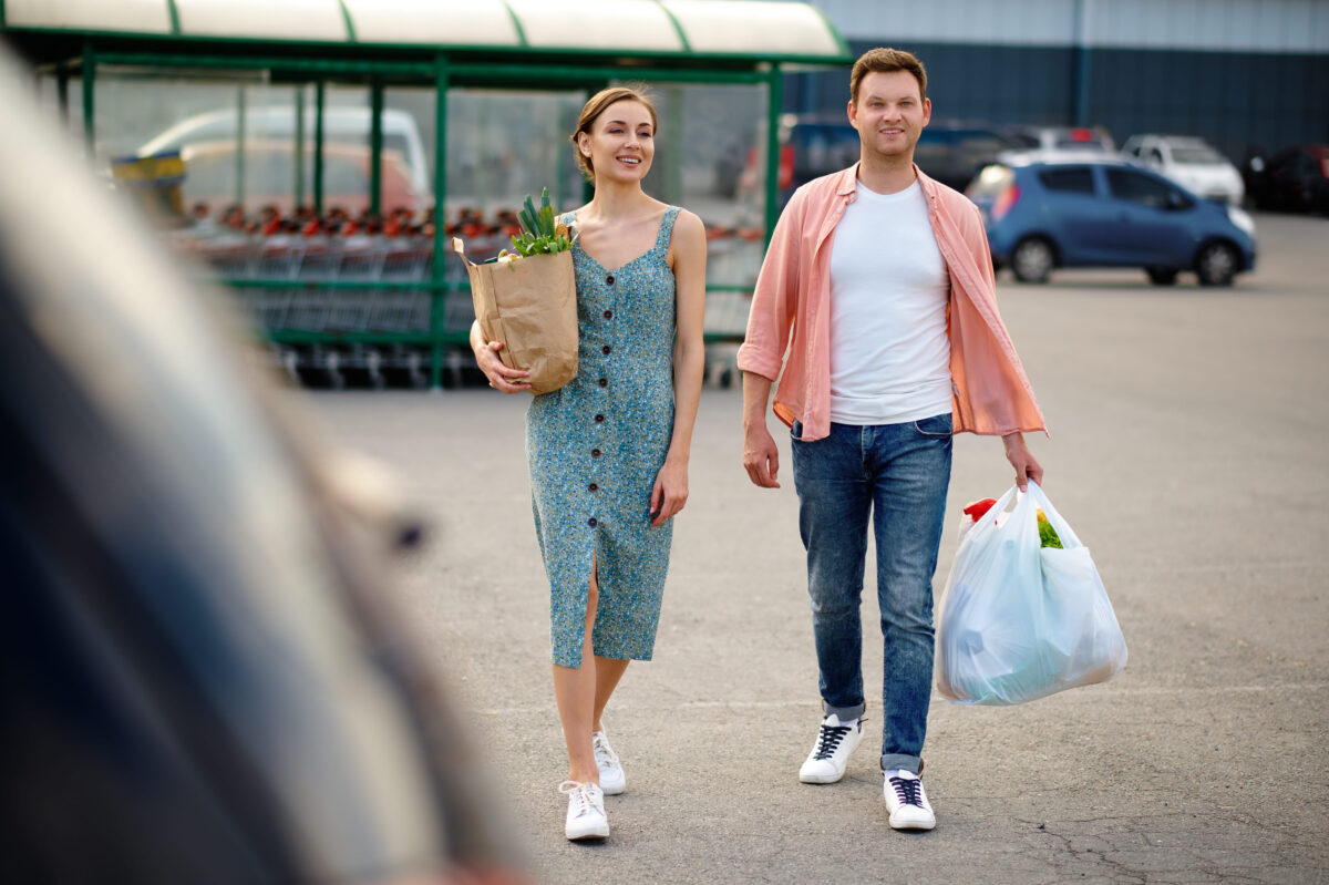 Young couple with bags on supermarket parking