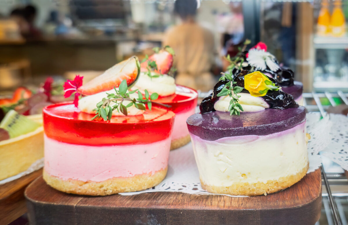 9 Things You Can't Legally Sell From Your Home Kitchen 3 Strawberry and blueberry cheese cakes on display at a cafA(C). Unrecognizable waiter and customers in the background.