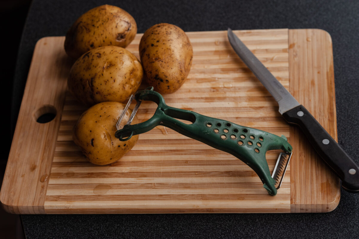 Wooden cutting board with a potato