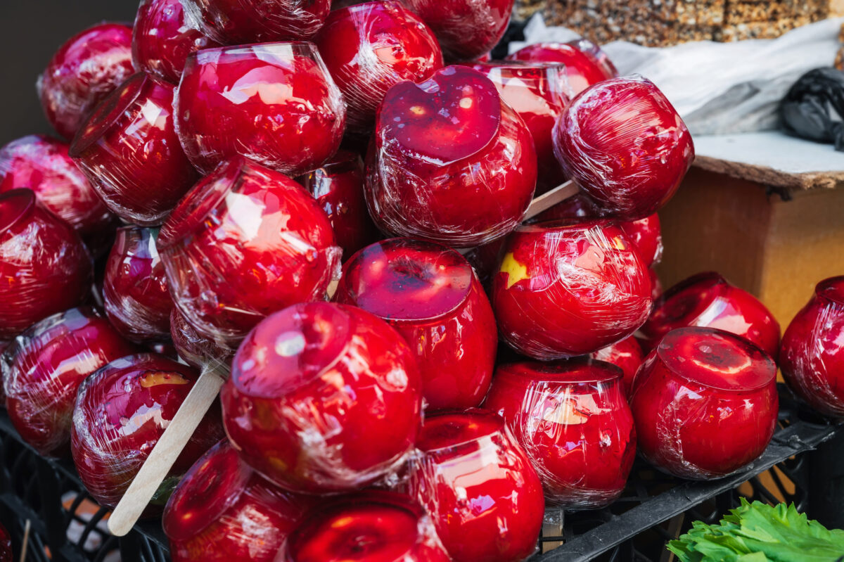 red caramel candy apples on sticks on market counter. A traditional sweet treat for Halloween