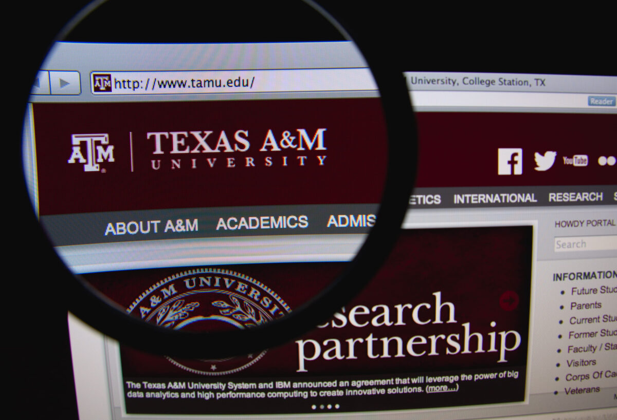 LISBON, PORTUGAL - FEBRUARY 21, 2014: Photo of the Texas A&M University homepage on a monitor screen through a magnifying glass.