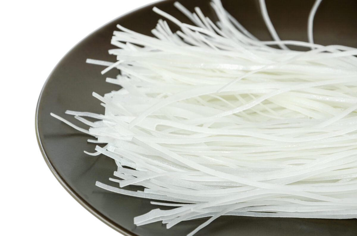 Asian food, close up dried rice noodles in dish on white background.