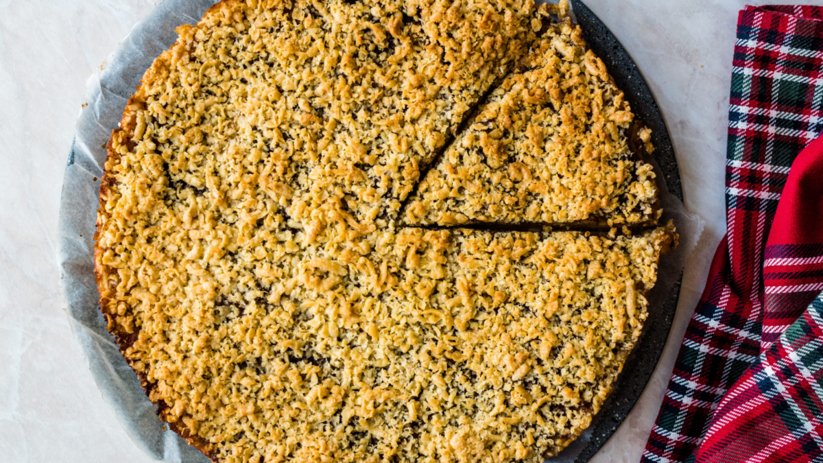 A delectable oat crumble dessert, perfectly golden-brown and sliced into servings, sits elegantly on a slate plate. Accompanied by a cozy plaid napkin, this treat promises warmth and sweetness for any gathering or celebration. Image Credit: alpaksoy/ 123RF