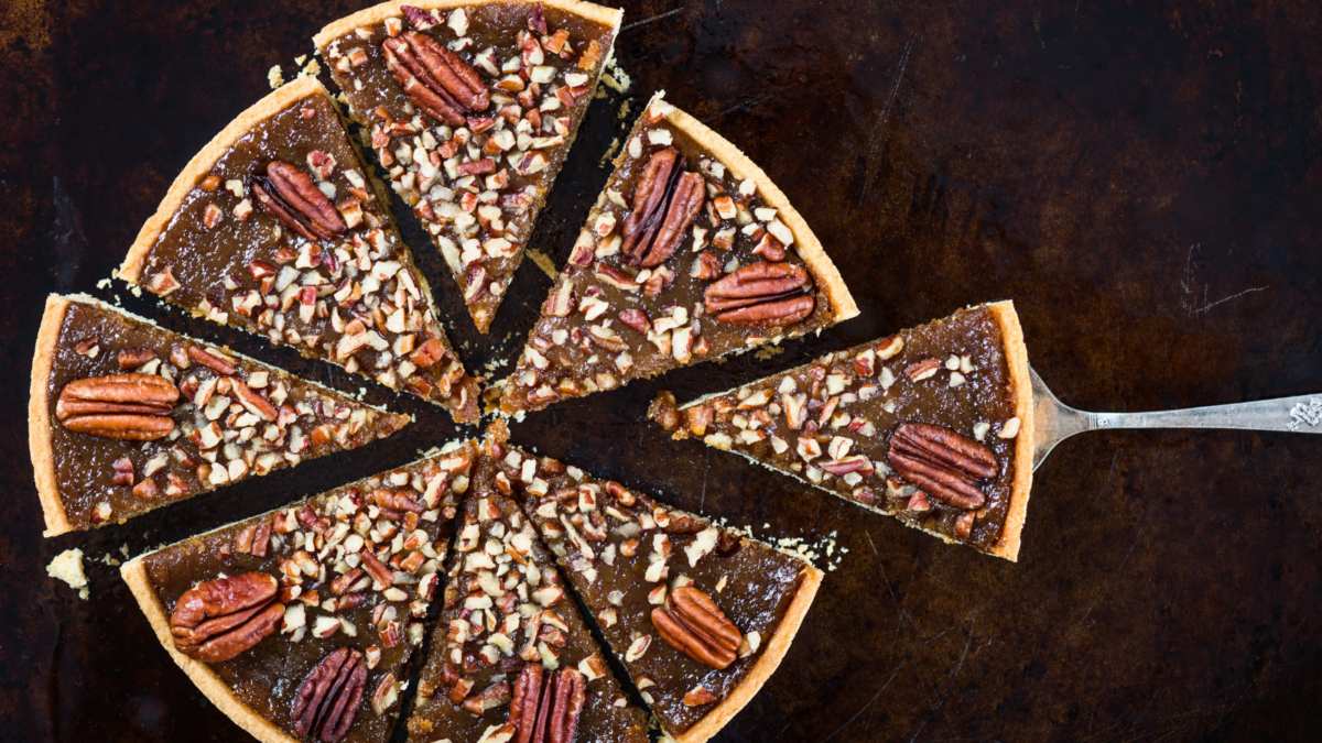 A delectable pecan pie, freshly sliced and ready to serve. Each slice reveals a rich, gooey filling studded with crunchy pecans, perfect for any dessert lover's gathering. The warm, golden crust complements the sweet, nutty flavor, making it an irresistible treat for festive occasions. Image Credit: manuta/ 123RF