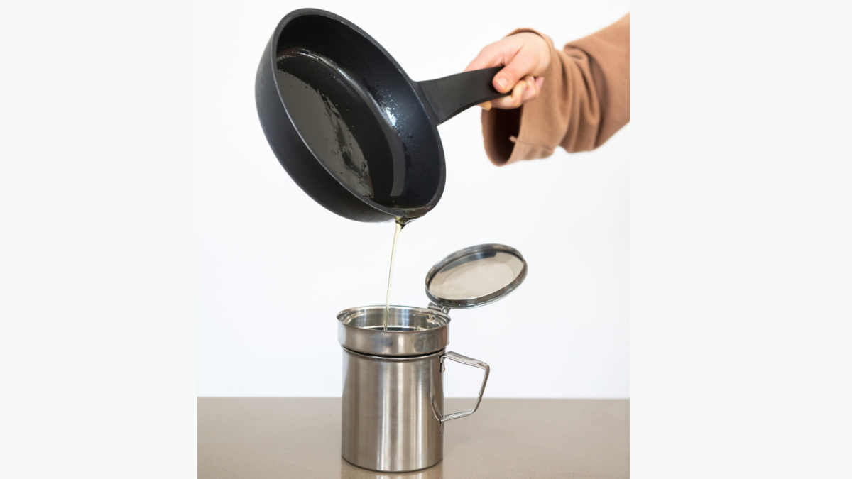 Woman pouring used cooking oil from an old frying pan into a metal cooking container.Oil recycling concept. Image Credit: javierlarraondo/ 123RF