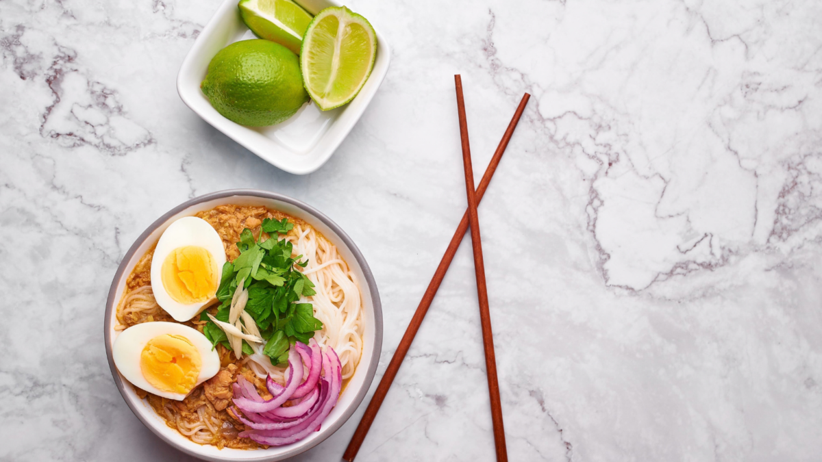 Homemade chicken soup with noodles, boiled egg and herbs close-up in a plate on the table. Image Credit: kravtzov/ 123RF