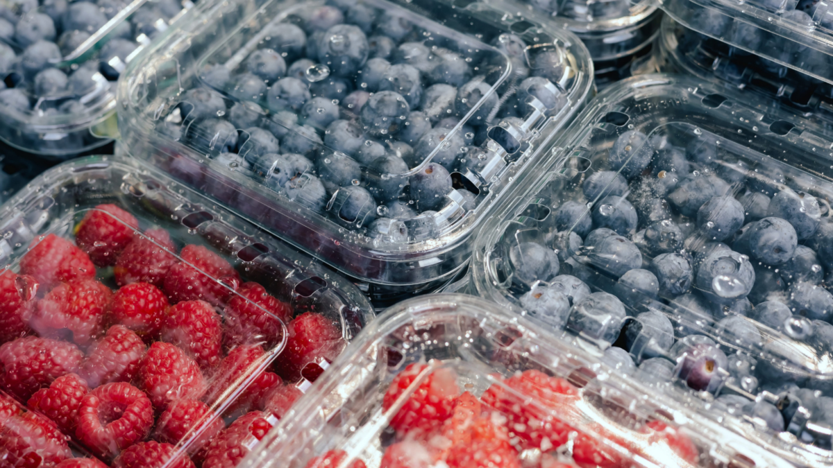 Fresh berry in plastic packaging at small local urban market. Organic produce on sale at outdoor farmer market. Selling fresh crops and veggies harvest. Image Credit: forewer/123RF
