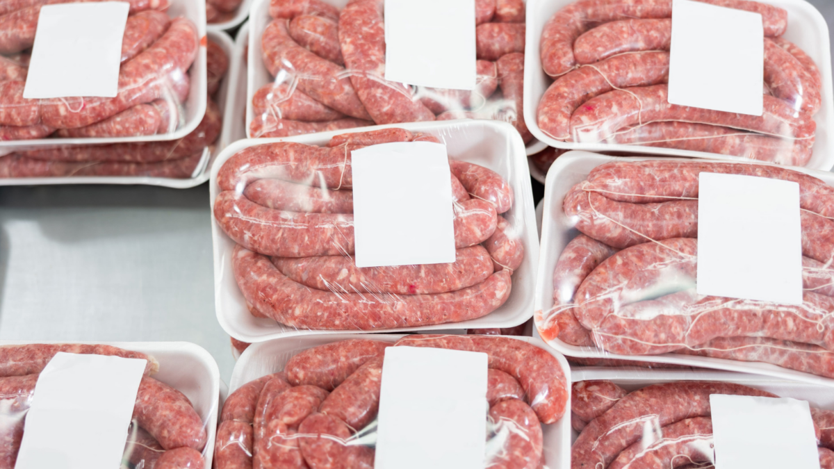 A bustling butcher shop showcases an array of fresh sausages, expertly packaged and ready for customers. Each tray presents a tempting assortment, perfect for grilling at a summer barbecue or adding flavor to hearty soups. Image Credit: jackf/ 123RF