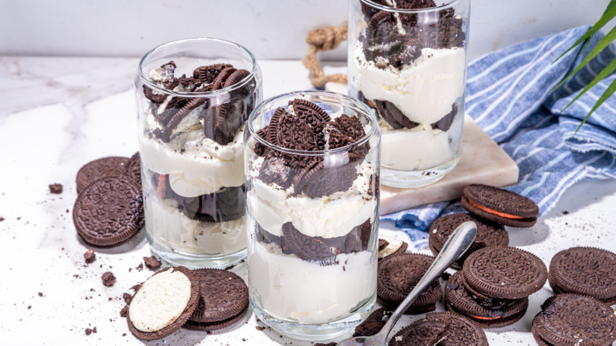 Cream and cookie layered dessert. Homemade vanilla chocolate cookie layered cheese cake in glass, variation of traditional american dessert