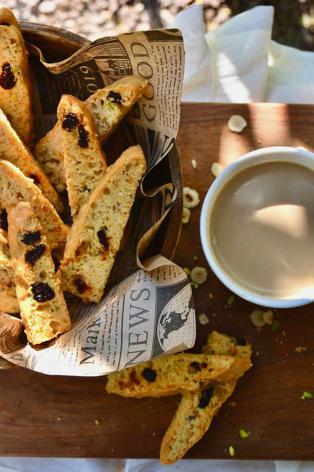 These Easy Pistachio Biscotti Could Be Your Coffee Break’s Best Upgrade 2 A basket of biscotti with a cup of coffee on a wooden table. Perfect cozy breakfast setup.