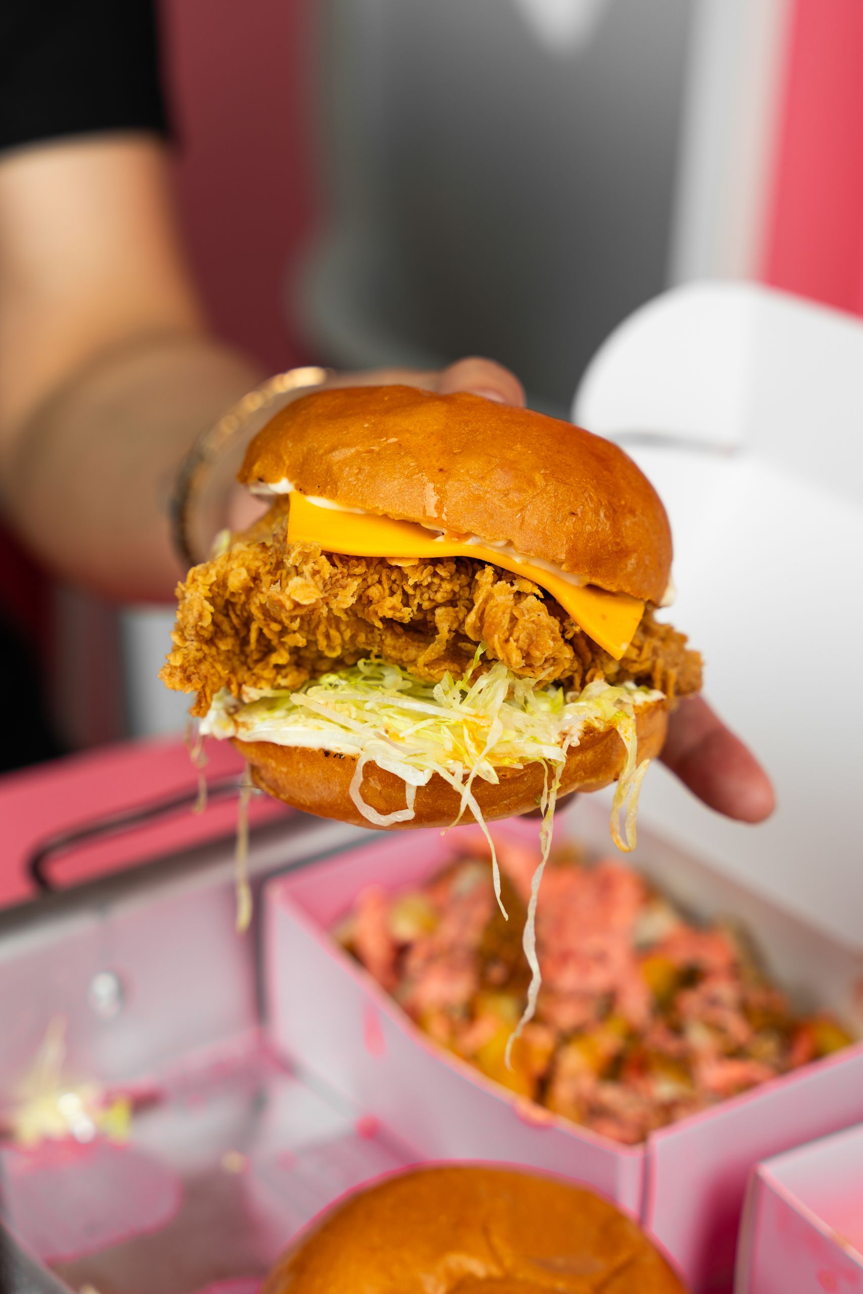 7 Fast Foods Gen Z Just Can’t Seem to Live Without 1 A close-up of a juicy fried chicken sandwich with cheese and lettuce, perfect for lunch.