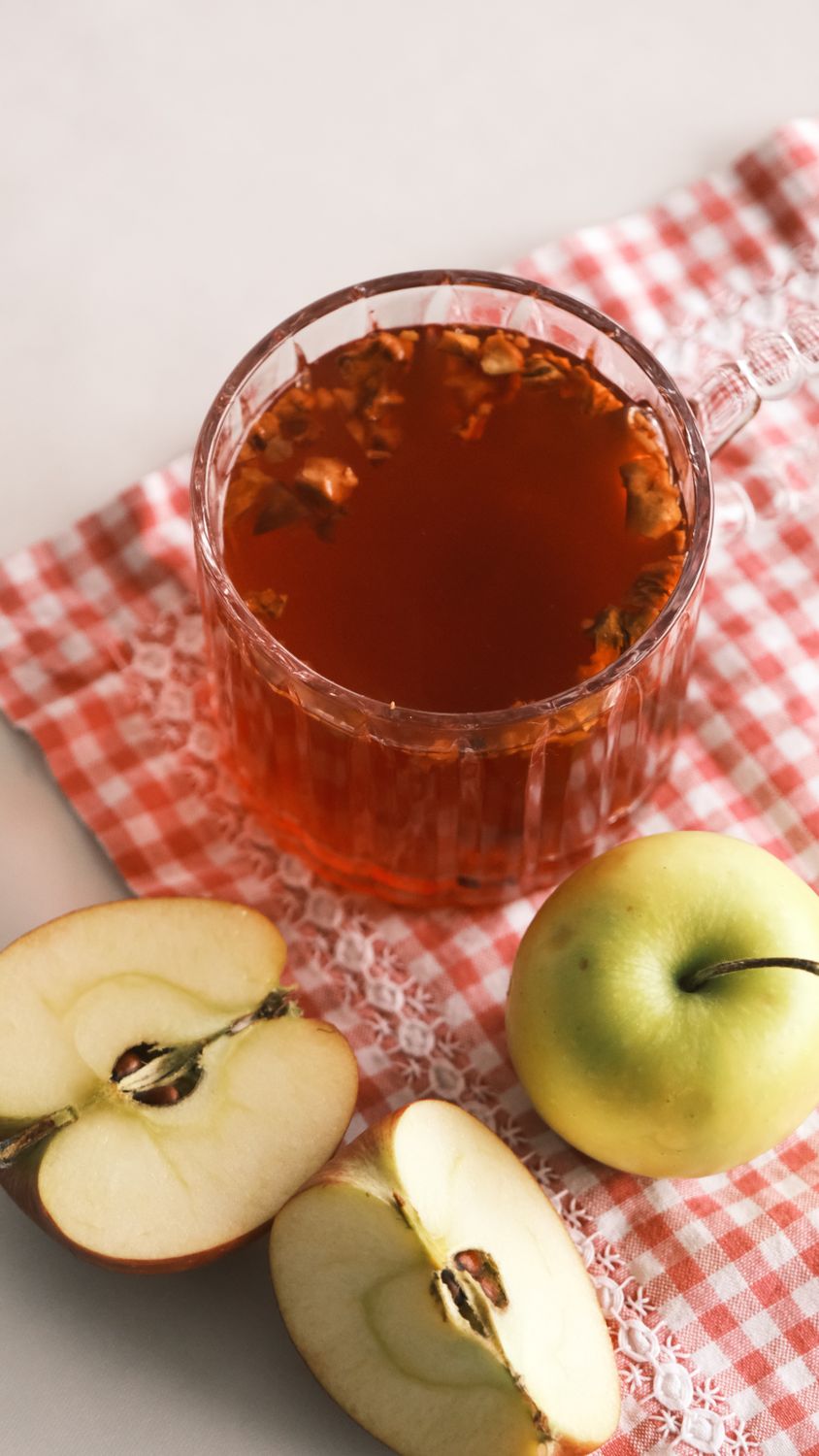 Move Over, Cider Donuts: New England’s Apple Cider Jelly Packs Fall Into a Jar 2 A cup of apple tea with fresh green apples on red checkered cloth.