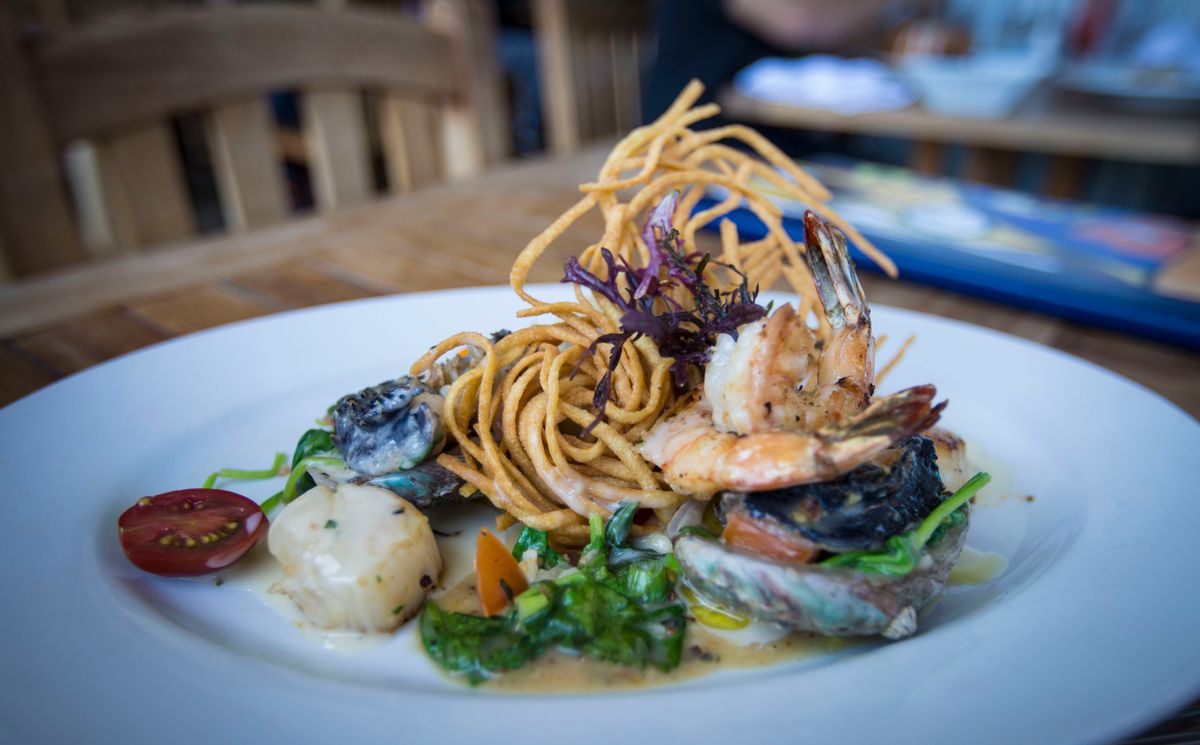Two Scoops of Rice, One Big Story: How Hawai‘i’s Plate Lunch Became an Island Favorite 1 A gourmet seafood dish featuring grilled shrimp, creamy sauce, and fried noodles served on a white plate.